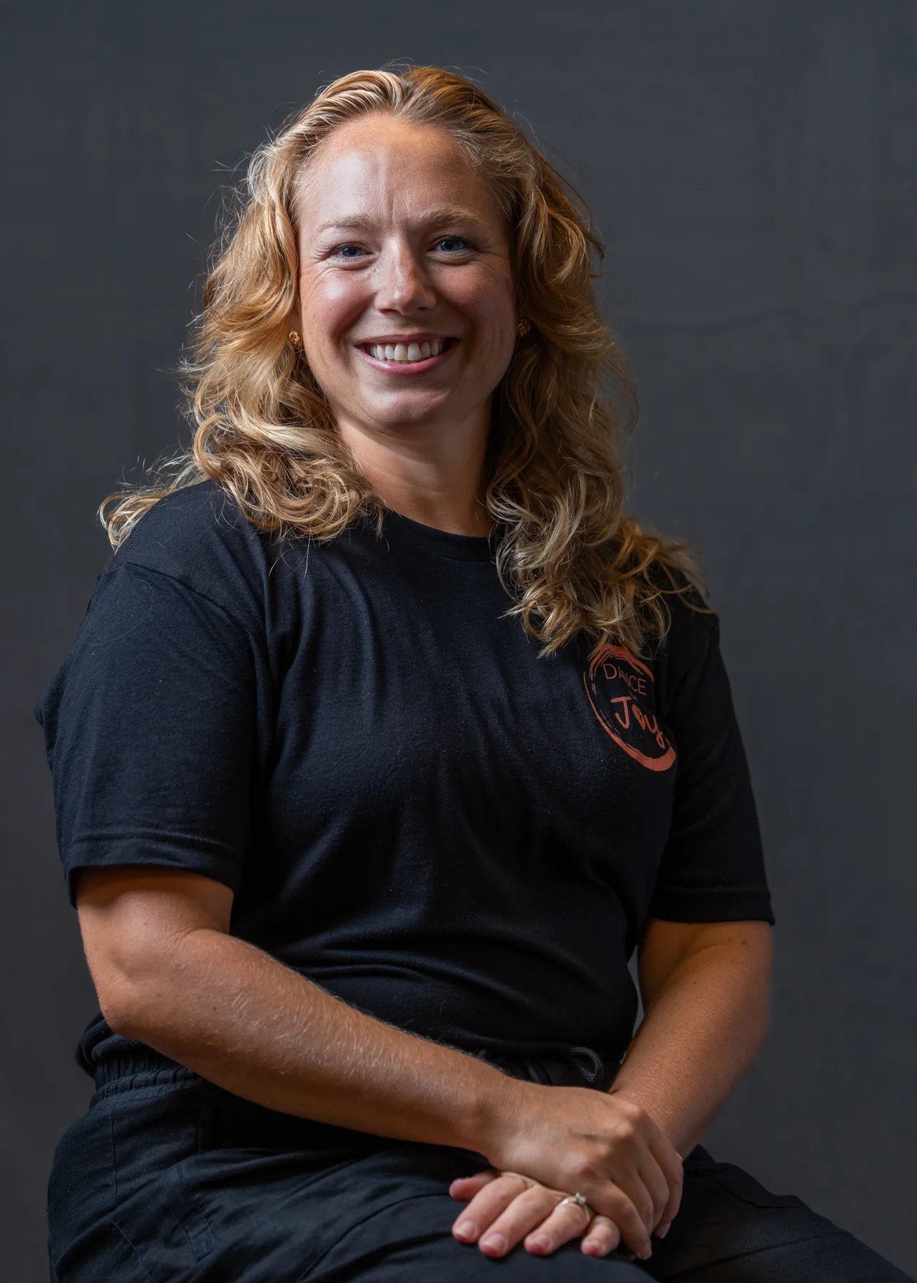 Dance with Joy team member smiling in a seated portrait